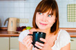 young  woman, enjoying a cup of coffee in her home.