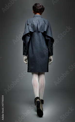 Photo: Fashion model brunette in grey coat walking away Fashion model brunette in grey coat walking away