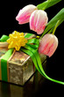 Pink tulips and gift box on black background