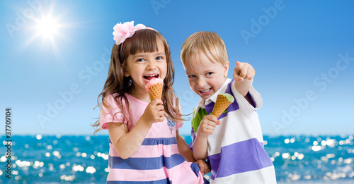 Foto: Children with icecream cone outdoor on seashore in hot summer da Children with icecream cone outdoor on seashore in hot summer da
