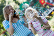 Two sisters having fun, making water bubbles.