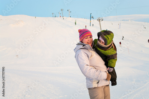 Photo: Mother and her little child standing on winter ski mountain Mother and her little child standing on winter ski mountain