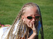 The girl in pink glasses with the African plaits