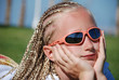 The girl in pink glasses with the African plaits