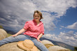 A girl with Down syndrome seated on a straw bale.