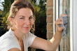 Junge Frau putzt Fenster
