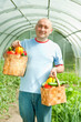 man with baskets of   vegetables