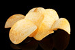 Delicious potato chips on black background