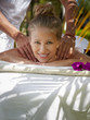 Happy young woman smiling during massage in spa
