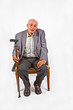 elderly man sitting in his armchair with walking stick elderly man sitting in his armchair with walking stick