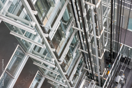 Photo: Looking down in an open steel lift shaft in a modern buldin Looking down in an open steel lift shaft in a modern buldin