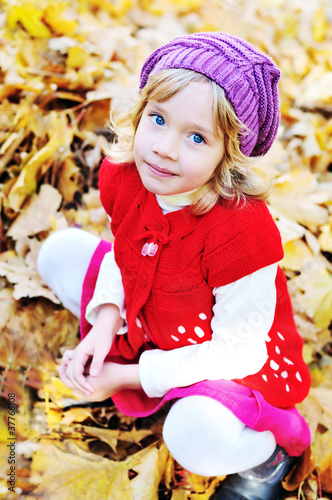 Photo: little blonde girl sitting in foliage little blonde girl sitting in foliage