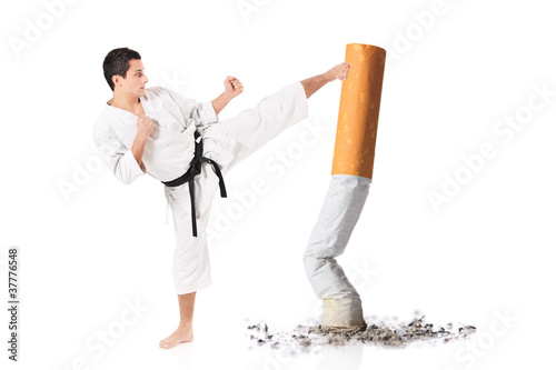 Photo: Karate man hitting a cigarette butt Karate man hitting a cigarette butt