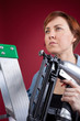 Woman on ladder holding nail gun
