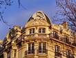 Immeuble de pierre blanche avec balcon.