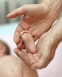 The little baby's legs in the hands of the big daddy