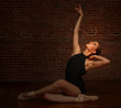 Ballerina Posing in Studio on Brick Background