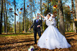Joyful bride and groom iand falling leaves