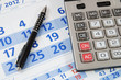 Photo: Calculator and black pen on calendar Calculator and black pen on calendar