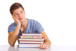 träumender Schüler hinter Bücherstapel