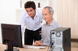 grandfather and grandson working together on a computer
