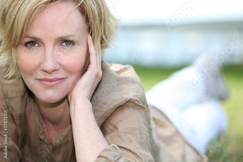 Photo: portrait of magnificent mature blonde lying on grass portrait of magnificent mature blonde lying on grass