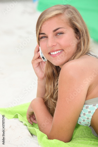 Photo: girl on the beach talking on her cell girl on the beach talking on her cell