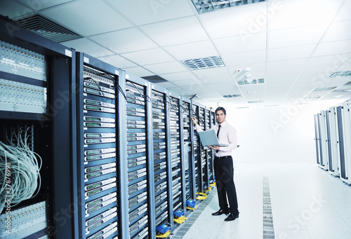 Foto: young it engeneer in datacenter server room young it engeneer in datacenter server room