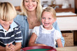 Foto: Young woman and children playing dices Young woman and children playing dices