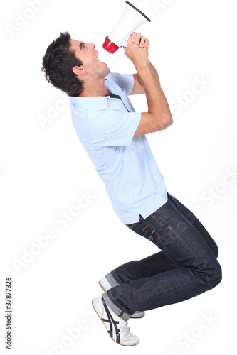 Photo: Young man shouting into a megaphone Young man shouting into a megaphone