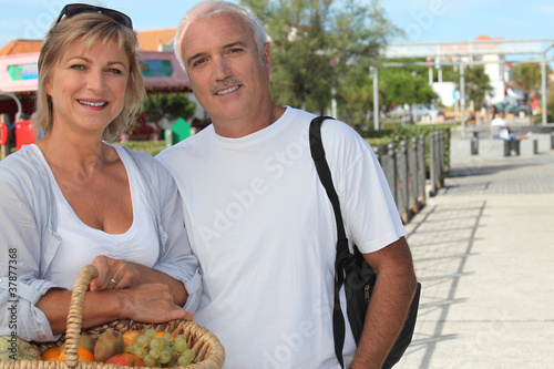 Photo: Couple on holiday with a basket of fruit Couple on holiday with a basket of fruit