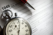 Tax form, red pen and stopwatch