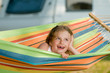 Summer camping - cute girl in colorful hammock