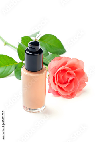 Photo: Closeup shot of foundation cream with a rose, on white Closeup shot of foundation cream with a rose, on white