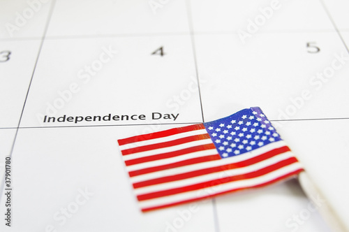 Photo: Calendar on the 4th of July and an American flag Calendar on the 4th of July and an American flag