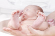 mother holding newborn baby girl while having a bath
