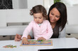 Little girl and woman doing puzzle