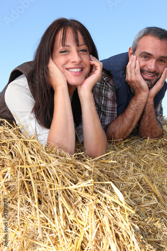 Photo: couple of farmers relaxing on a strawbale couple of farmers relaxing on a strawbale