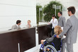 Businesswoman in a wheelchair with her colleagues at reception
