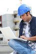 Foto: A foreman checking his laptop onsite. A foreman checking his laptop onsite.