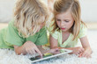 Siblings on the floor using tablet