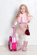 Little cute tourist girl with her baggage