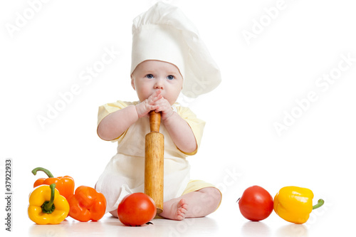 Photo: Portrait of a baby wearing a chef hat with healthy food vegetab Portrait of a baby wearing a chef hat with healthy food vegetab