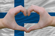 Heart and love gesture showed by hands over flag of finland back
