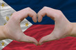 Heart and love gesture showed by hands over flag of phillipines