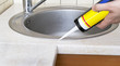 Plumber putting a silicone sealant to installing a kitchen sink