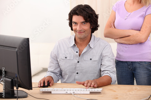 Photo: a man doing computer and an angry woman a man doing computer and an angry woman