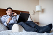 Hispanic businessman using laptop in his hotel room