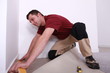 handyman laying wall-to-wall carpet