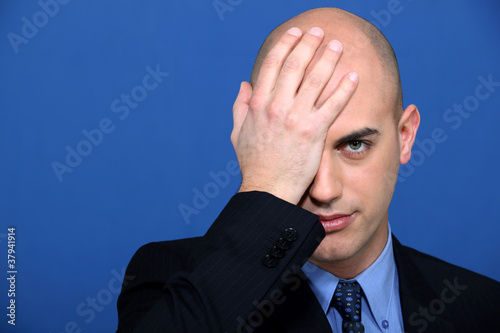 Photo: Businessman holding his hand to his face Businessman holding his hand to his face